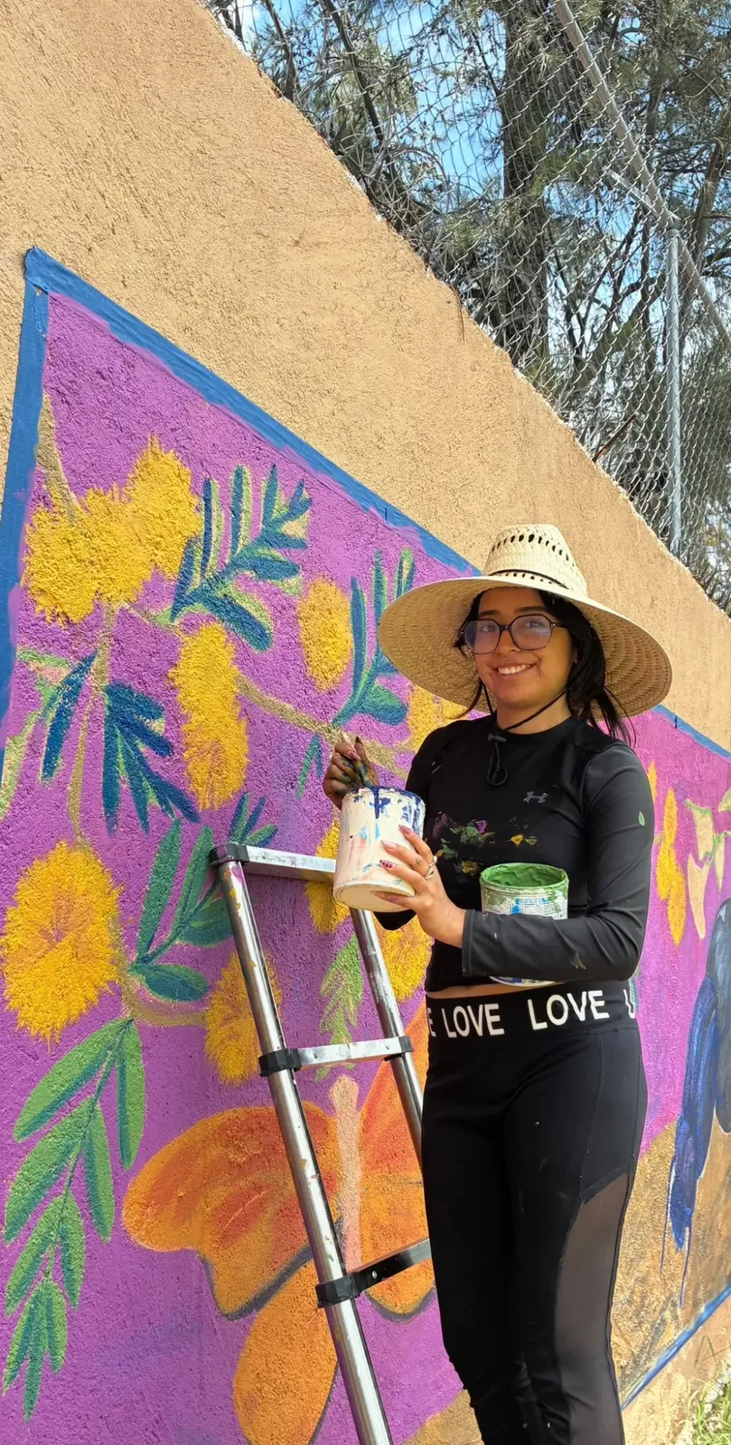 Artist painting a colorful mural from the La Vida de Las Cachinches project in San Miguel de Allende